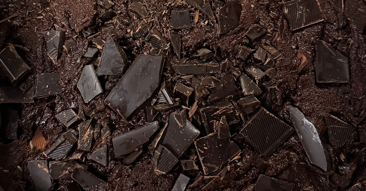a close-up view of chocolate chunks on the surface of brownie batter