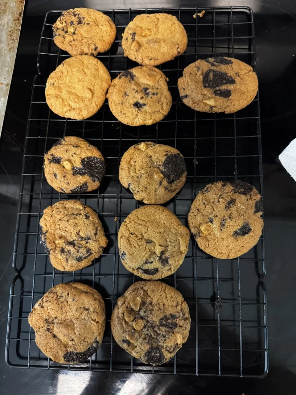 twelve freshly baked cookies resting on a cooling rack