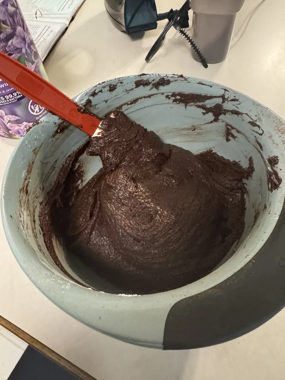 a mixing bowl containing thick chocolate batter, with no white streaks present any more