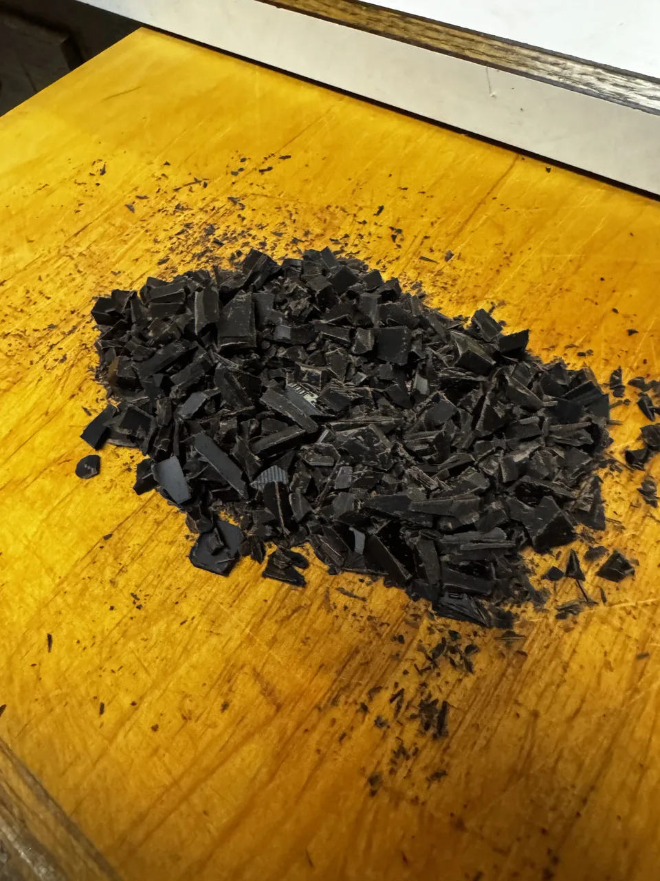 roughly chopped chocolate pieces sitting on a wooden cutting board
