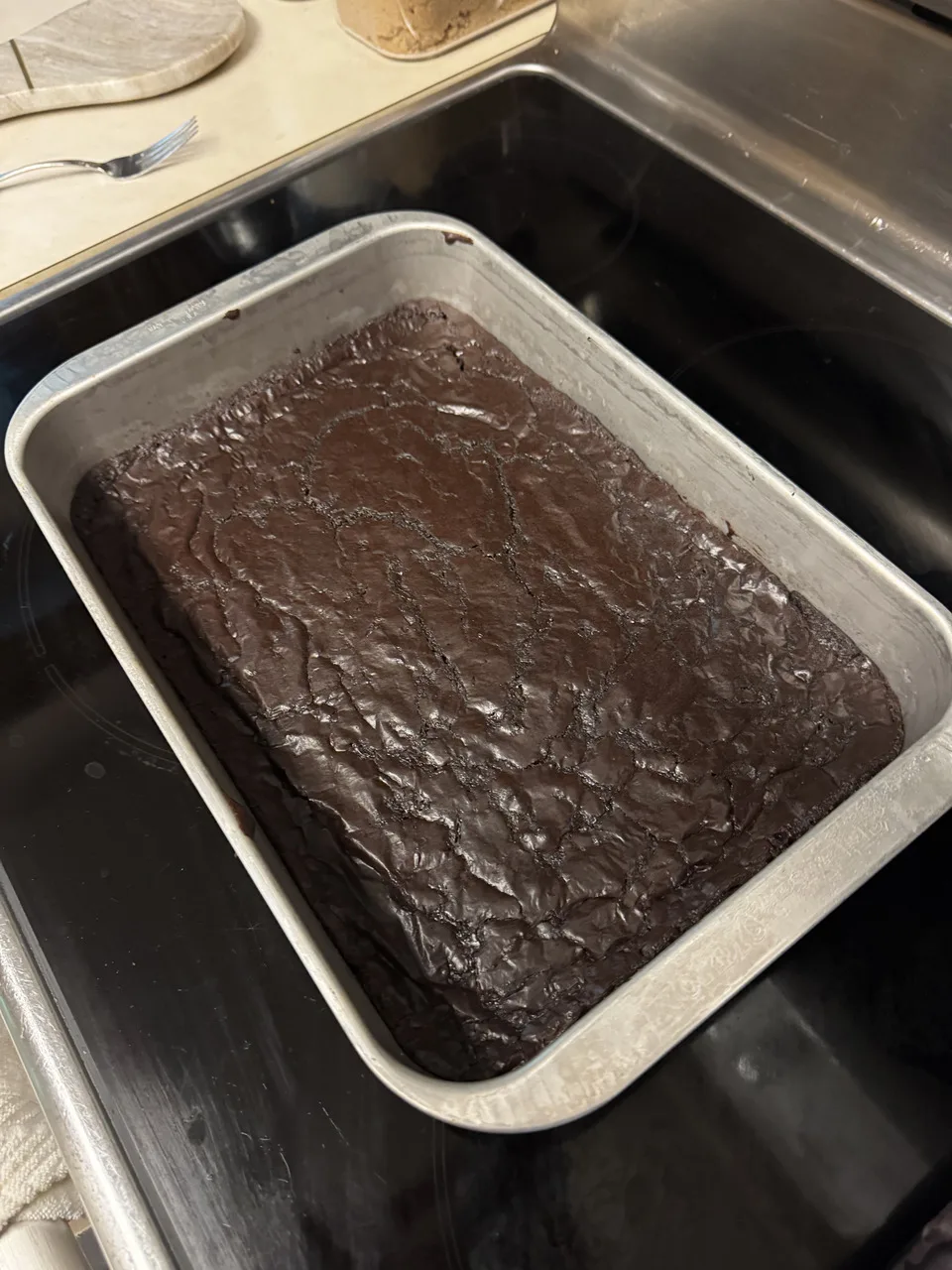 a tray of brownies in a metal sheet pan, freshly removed from the oven