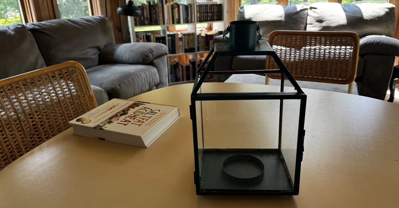 an enclosure made of black metal and glass sitting next to a cookbook on a table