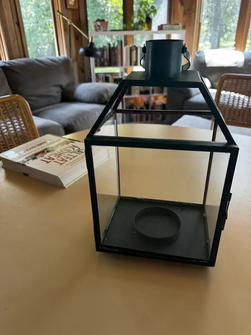 a zoomed-in view of an enclosure made of black metal and glass sitting next to a cookbook on a table