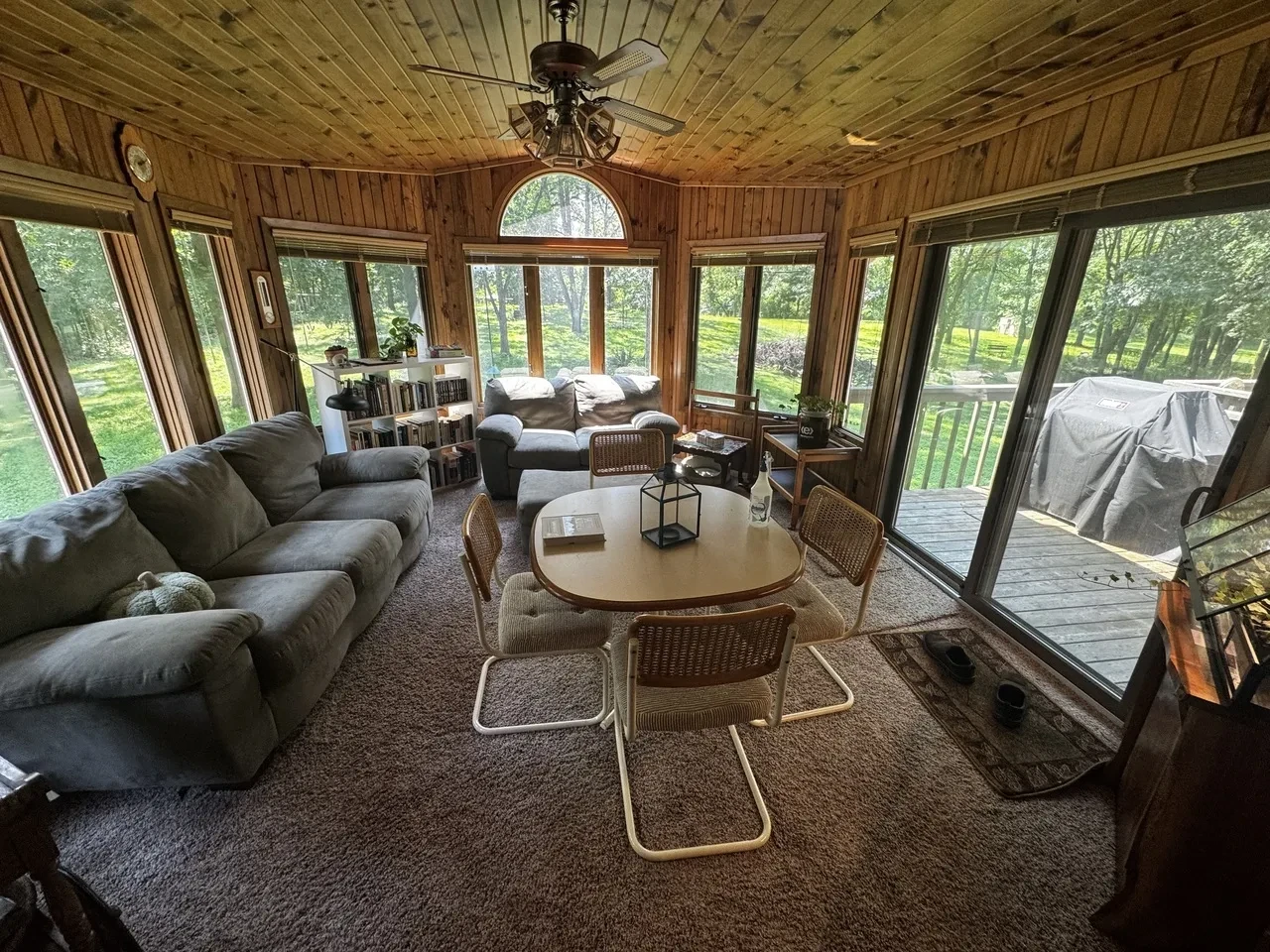a wide-angle shot of a well-furnished room brightly lit from windows on all sides